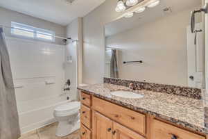 Full bathroom featuring vanity, shower / tub combo, tile patterned floors, and toilet