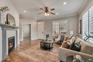 Living room featuring crown molding, ceiling fan, and hardwood / wood-style flooring