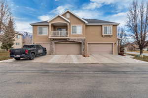 View of front of house featuring a balcony and a garage