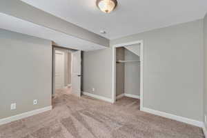 Unfurnished bedroom featuring light colored carpet, a closet, and a textured ceiling