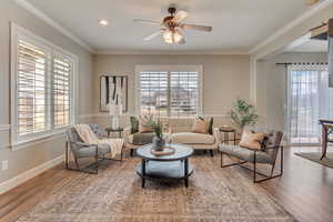 Living room featuring ornamental molding, a healthy amount of sunlight, and hardwood / wood-style floors