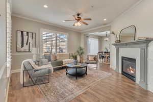 Living room featuring crown molding, ceiling fan, and hardwood / wood-style floors