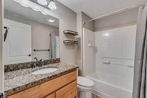 Full bathroom with shower / tub combo with curtain, vanity, and toilet