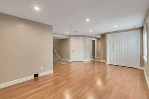 Basement with light hardwood / wood-style floors