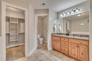 Bathroom featuring vanity, tile patterned floors, toilet, and a textured ceiling