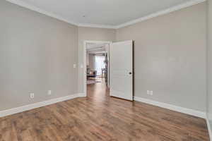 Empty room featuring crown molding and hardwood / wood-style flooring