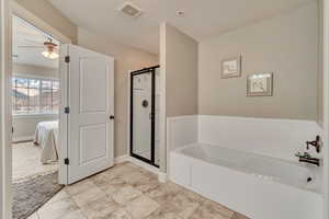 Bathroom featuring a textured ceiling, shower with separate bathtub, and ceiling fan