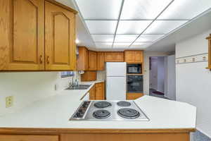 Kitchen featuring sink, black appliances, and kitchen peninsula