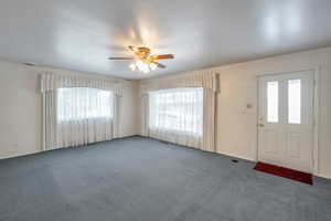 Carpeted foyer featuring ceiling fan