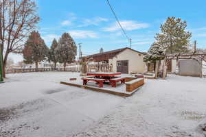 Snow covered back of property with an outdoor structure