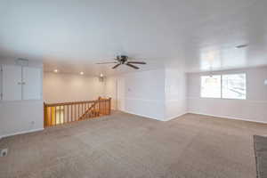 Carpeted empty room with ceiling fan