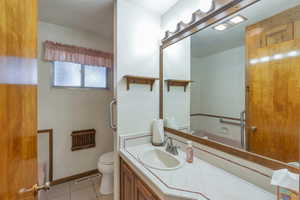 Bathroom featuring tile patterned floors, vanity, and toilet