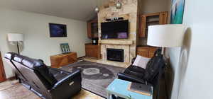 Living room featuring vaulted ceiling and a large fireplace