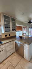 Kitchen featuring ceiling fan, stainless steel dishwasher, stone countertops, and kitchen peninsula