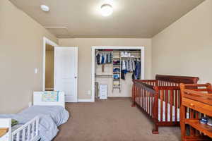 Carpeted bedroom with a closet and a textured ceiling