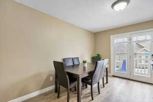 Dining space featuring a healthy amount of sunlight, a textured ceiling, and light wood-type flooring