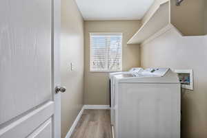 Laundry room featuring separate washer and dryer and light wood-type flooring