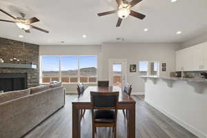 Dining room with hardwood / wood-style flooring, ceiling fan, a mountain view, and a fireplace