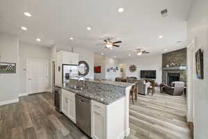 Kitchen with an island with sink, appliances with stainless steel finishes, sink, and white cabinets