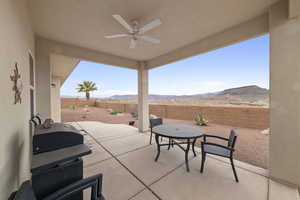 View of patio featuring a mountain view, ceiling fan, and a grill