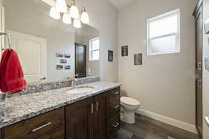 Bathroom featuring vanity, toilet, a chandelier, and hardwood / wood-style floors