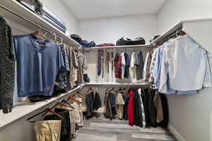 Spacious closet with hardwood / wood-style floors