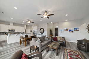 Living room with ceiling fan and light hardwood / wood-style floors