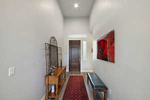 Hallway featuring hardwood / wood-style floors and a high ceiling