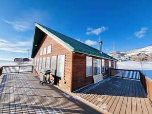 Snow covered deck featuring area for grilling and a mountain view