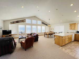 Living room with vaulted ceiling and light colored carpet