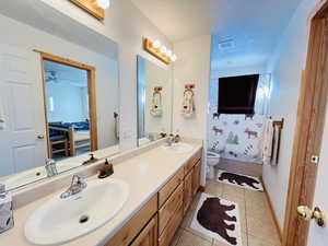 Bathroom featuring vanity, toilet, tile patterned flooring, and a textured ceiling