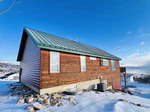 View of snowy exterior with central air condition unit
