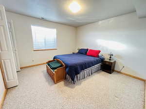 Bedroom with a textured ceiling and carpet