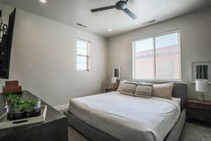 Carpeted bedroom with ceiling fan and a textured ceiling