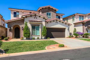 Mediterranean / spanish-style house featuring a garage and a front lawn