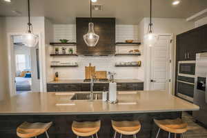 Kitchen featuring a spacious island, appliances with stainless steel finishes, and a breakfast bar area