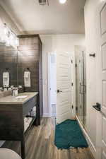 Bathroom with vanity, wood-type flooring, and walk in shower