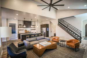 Living room with lofted ceiling, wood-type flooring, and ceiling fan