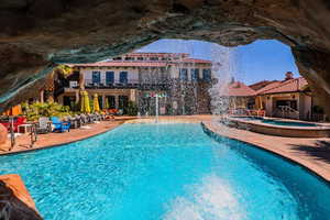 View of swimming pool with a patio area, a hot tub, and pool water feature