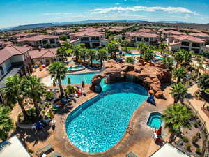 View of swimming pool with a patio, a mountain view, and a community hot tub