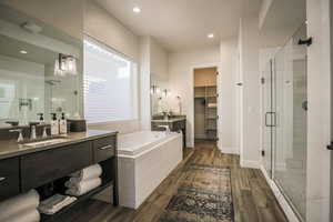 Bathroom featuring wood-type flooring, separate shower and tub, and vanity