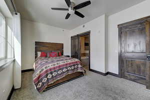 Bedroom featuring multiple windows, a barn door, and carpet floors