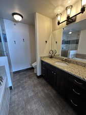 Full bathroom featuring independent shower and bath, vanity, a textured ceiling, and toilet