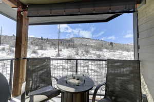 Snow covered back of property with a mountain view