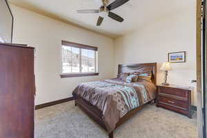 Carpeted bedroom featuring ceiling fan