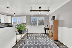 Interior space with white cabinetry, pendant lighting, and dark wood-type flooring