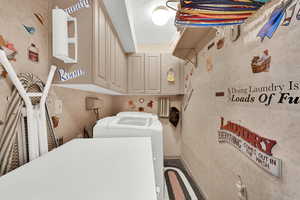 Washroom featuring cabinets and separate washer and dryer