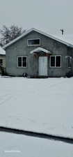 Snow covered back of property featuring stucco siding