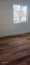 Unfurnished room with dark wood-type flooring