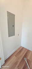 Empty room with wood-type flooring and electric panel